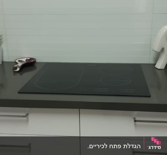 שיש כהה עם כיריים אינדוקציה במטבח מודרני